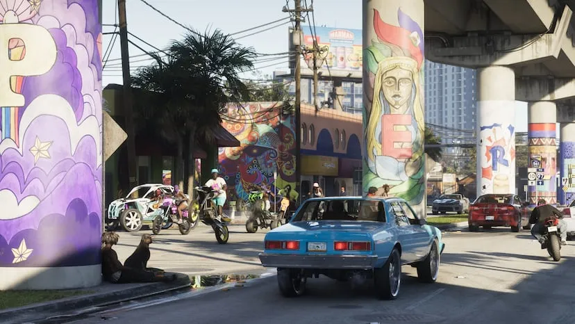 Vice City dans GTA VI : rue aux fresques latino colorées sous une voie rapide, voitures anciennes